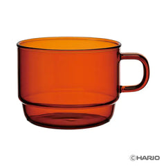 Red-orange heatproof glass stackable mug with black handle, full view.