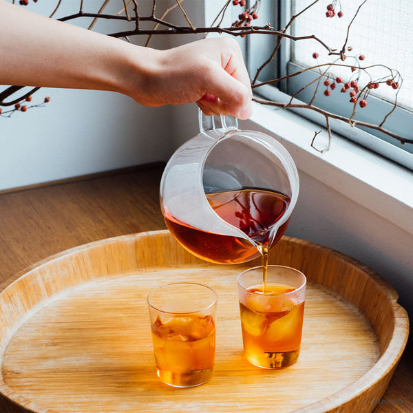Complete Largo dripper assembly displayed with glass server and loose tea leaves in preparation.