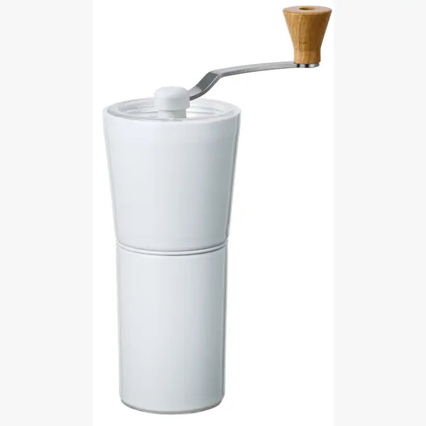 White ceramic coffee grinder with wooden knob crank handle against plain background.