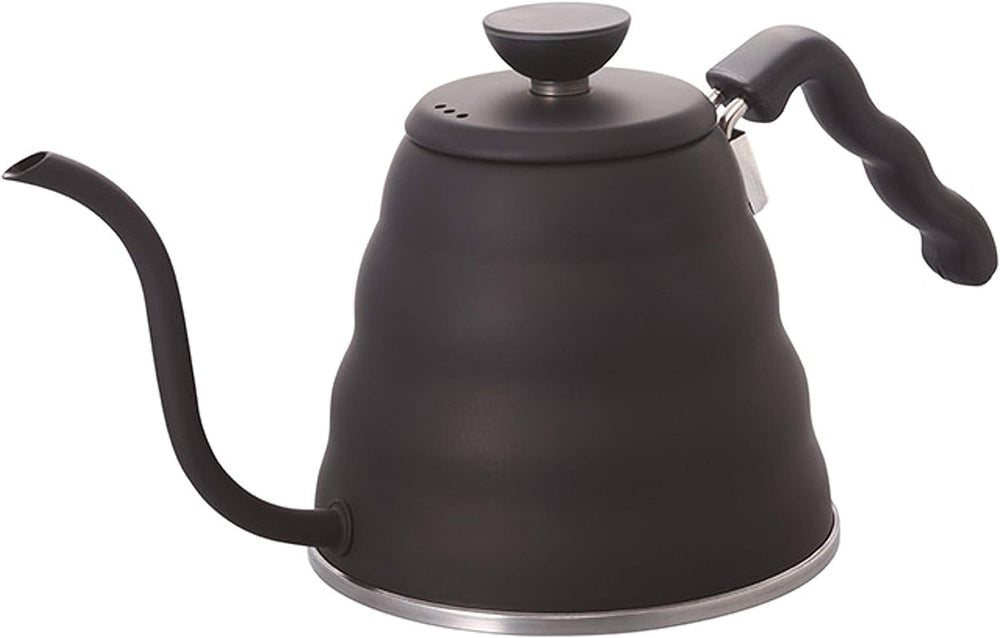 Person pouring hot water from black gooseneck kettle into white coffee dripper positioned over glass carafe on wooden table.