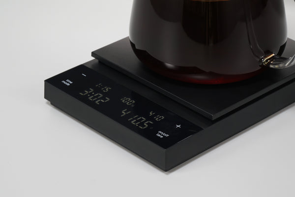 Dark glass carafe of brewed coffee sitting on black Polaris scale with digital display