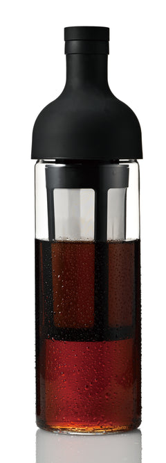 Black Hario filter-in bottle filled with dark cold brew coffee against white background.