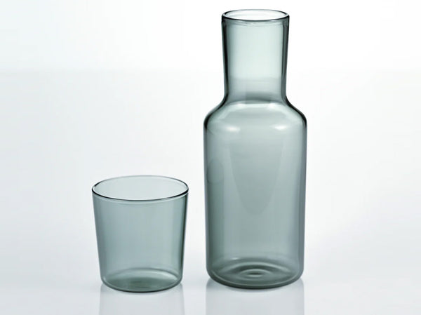 Gray glass carafe and cup set displayed as complete duo on white background.