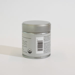 Silver tin container showing back label with usage instructions and barcode.