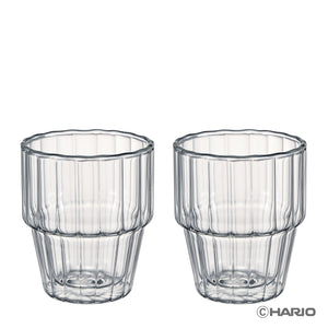 Two matching clear double-walled stackable glasses with vertical ribbed design and segmented base, displayed side by side.