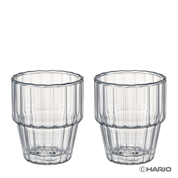 Two matching clear double-walled stackable glasses with vertical ribbed design and segmented base, displayed side by side.