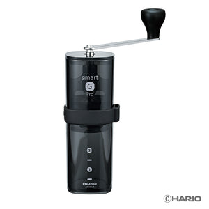 Close-up front view of black Hario Smart G Pro coffee mill with hand crank handle extended.