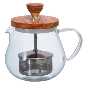 Glass teapot with olive wood lid and metal infuser basket visible inside