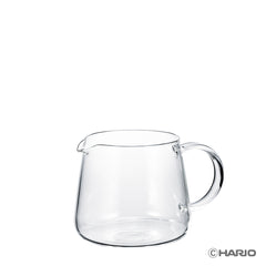 Empty clear glass carafe with handle and spout on white background, product showcase angle.