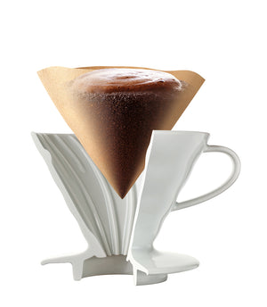 White V60 dripper filled with brewed coffee and white paper filter.