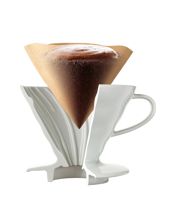 White V60 dripper filled with brewed coffee and white paper filter.