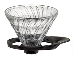 Clear glass V60 dripper cone with distinctive spiral ribbed interior texture and black base stand.