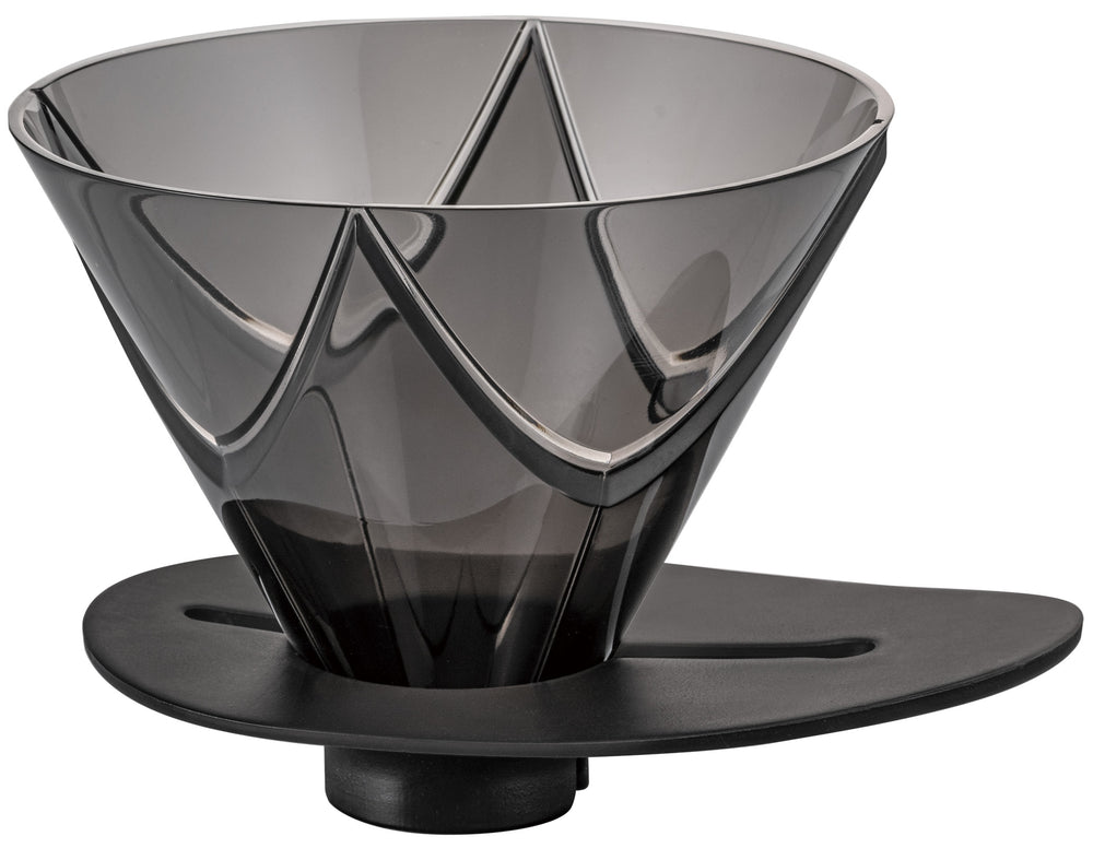 Person pouring hot water from black kettle into Hario V60 dripper over black mug on wooden table