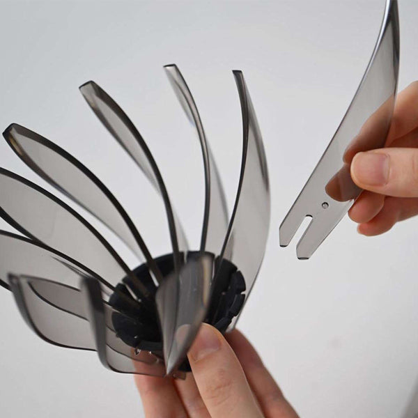 Hands demonstrating V60 Suiren dripper assembly with separate metal bracket piece being positioned alongside transparent