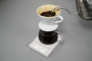 Polaris scale with ceramic dripper dripping brewed coffee into glass carafe