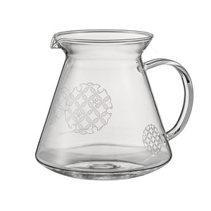 Empty glass server with etched Shippou pattern circles and pouring spout on white background