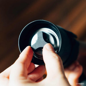 Close-up of internal stainless steel burr mechanism visible through grinder opening