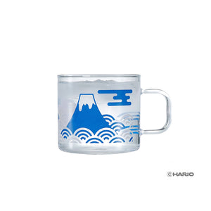 Clear glass mug with Mount Fuji illustration in blue and wavy cloud pattern design.