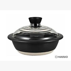 Black donabe pot with glass lid shown from side angle against white background, revealing shape.