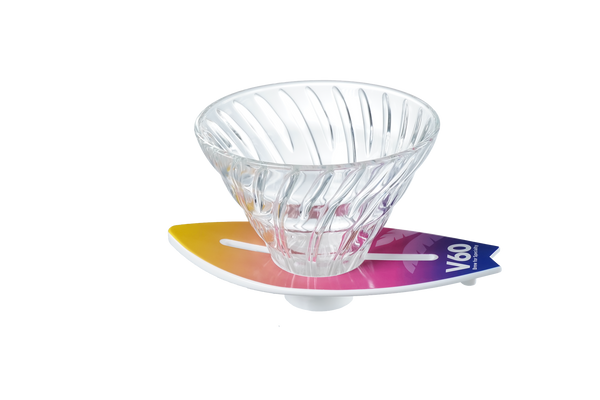 V60 dripper centered on yellow-to-magenta gradient surfboard stand, minimalist white background.