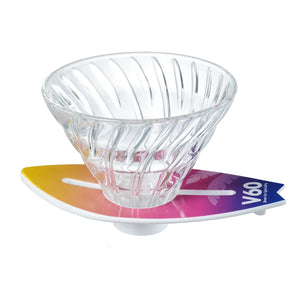 V60 dripper on yellow-to-magenta ombre surfboard base, slightly elevated perspective.