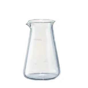 Empty clear glass conical pitcher with measurement marks and pouring spout, shown against white background.